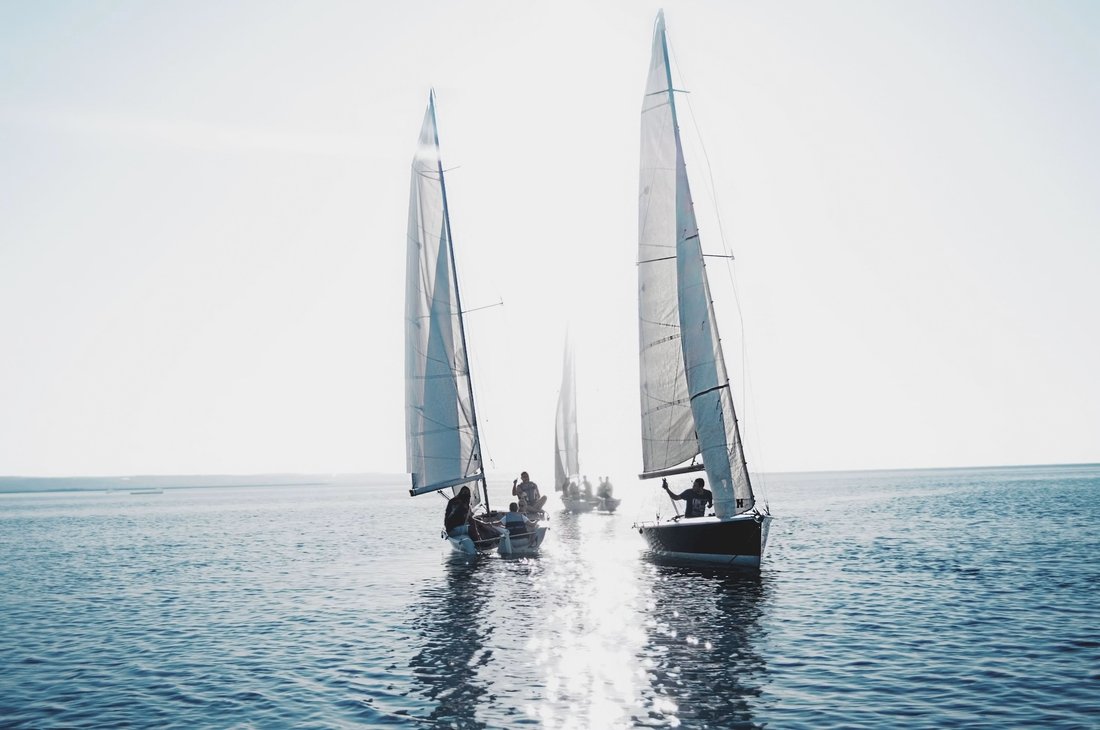 Segelboote mit Crew auf offenem Wasser, Sinnbild für Freiräume und Selbstorganisation